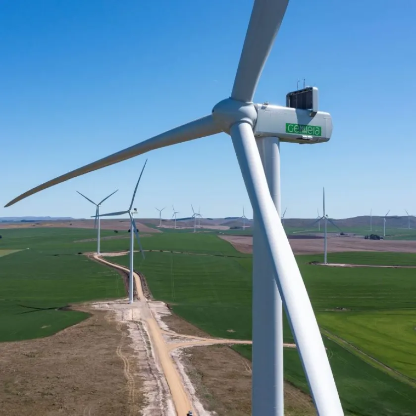 Eolienne au premier plan et champ d'éoliennes à l'arrière-plan