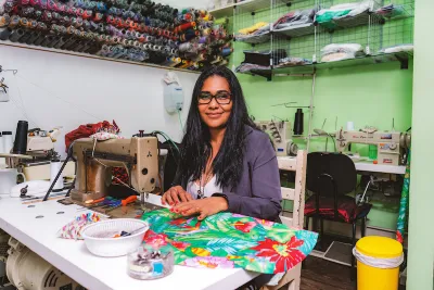 Seamstress smiling at camera while she works