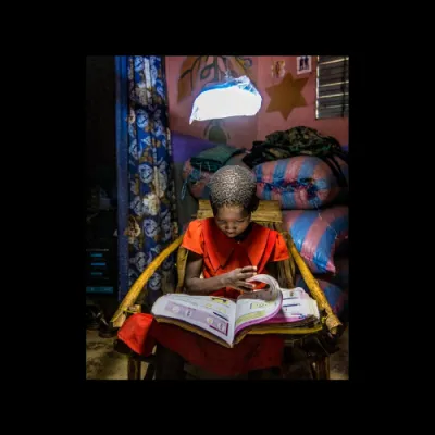 Child reading a book in a dark room