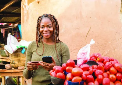 Woman smiling next to crate of tomatoes