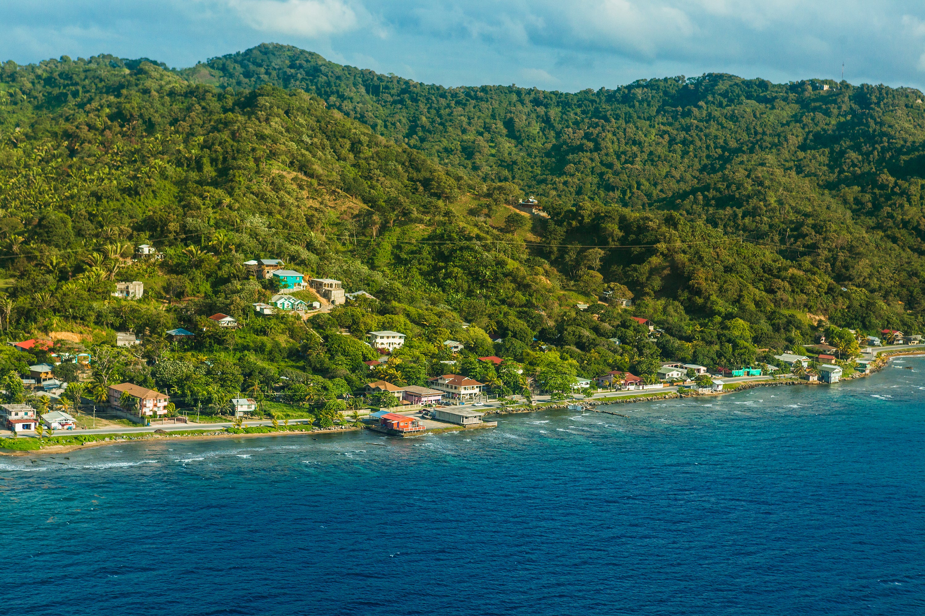 Banco del País: Image of a hillside meeting a waterfront with houses and cottages at the bottom.