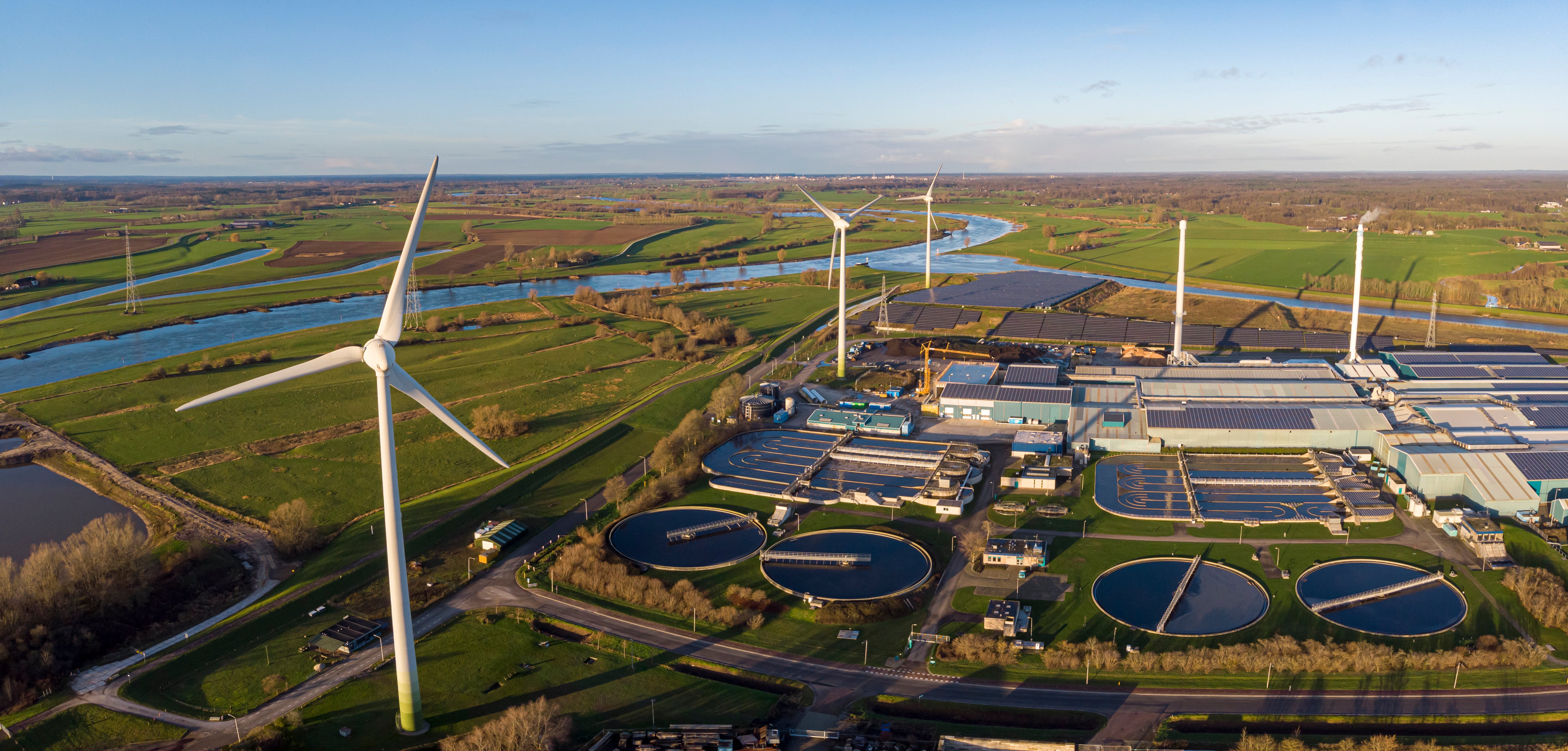 Climate Policy Initiative: Image of wind turbines alongside a water treatment facility.