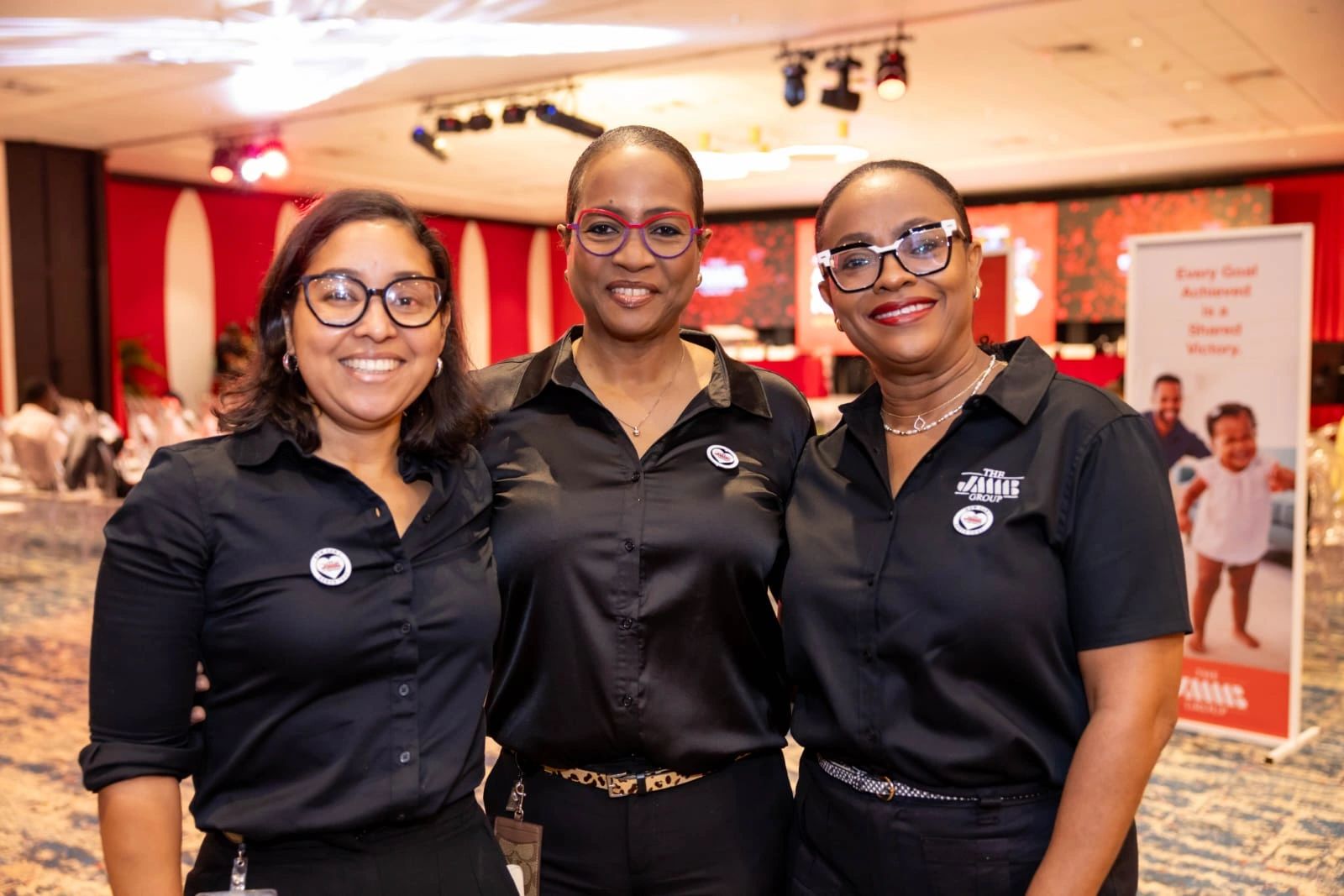 Three employees of JMMB smiling during a conference