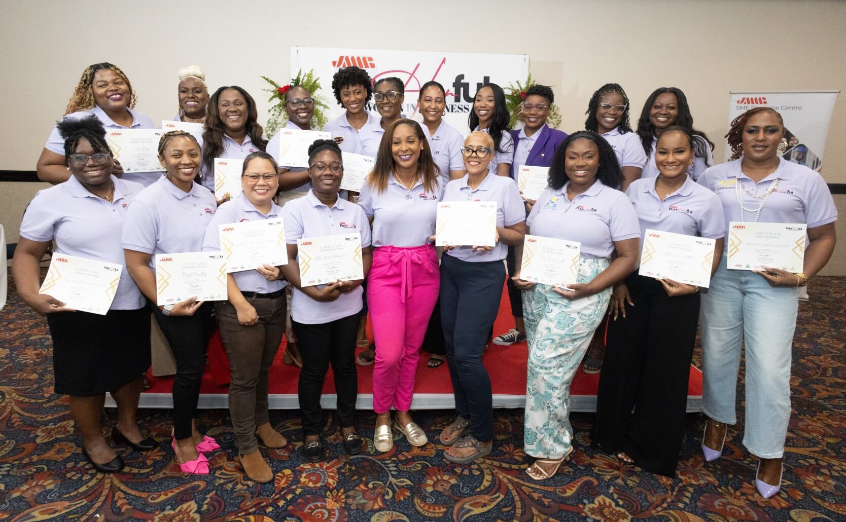 A group of women standing together, each holding a certificate, in front of a banner that reads “Powerful Women in Business.”